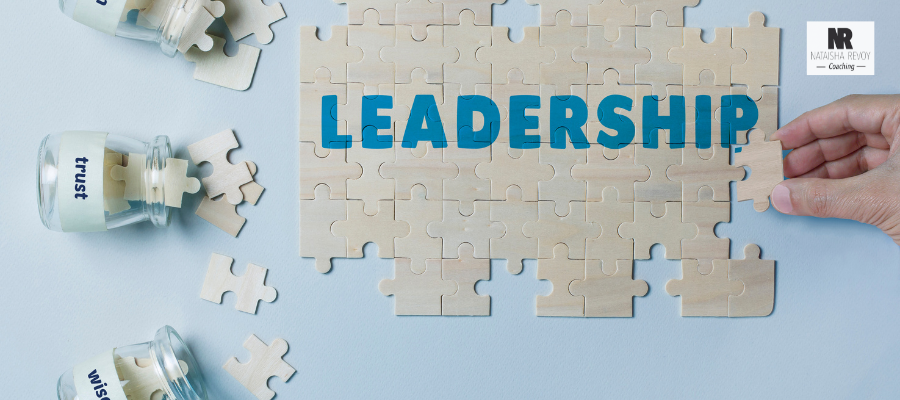 A wooden puzzle with the word 'Leadership' in bold letters, symbolizing the process of building leadership skills, with jars labeled 'trust' and 'wisdom.