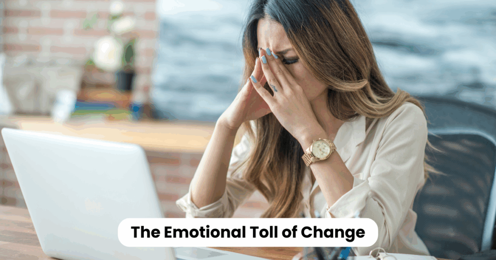 Stressed professional woman sitting at desk with head in hands, representing the emotional toll of leadership in times of change.