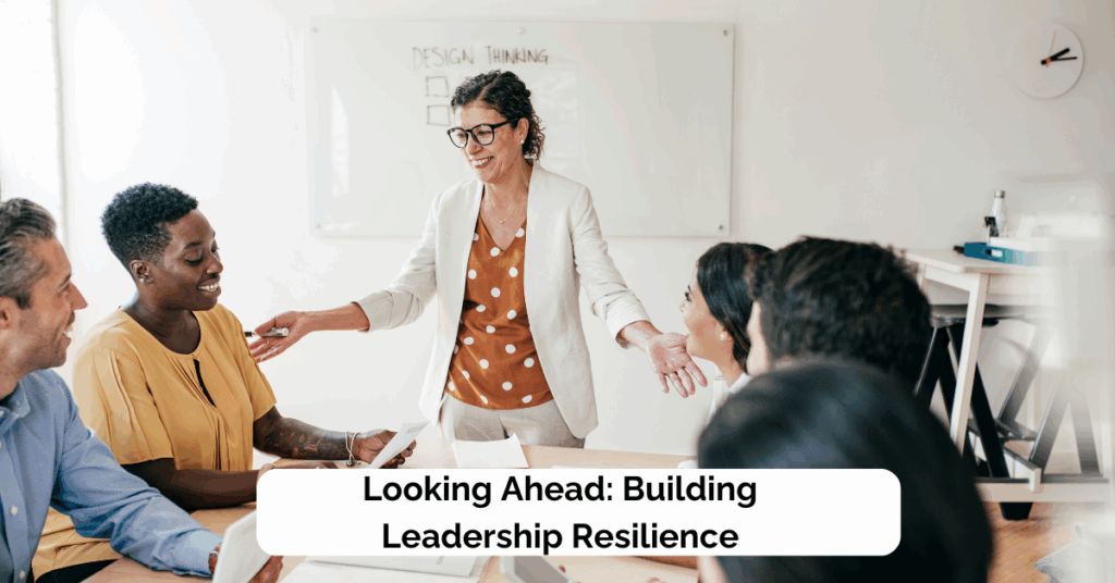 Smiling leader connecting with diverse team in a meeting, representing resilience, connection, and adaptive leadership.